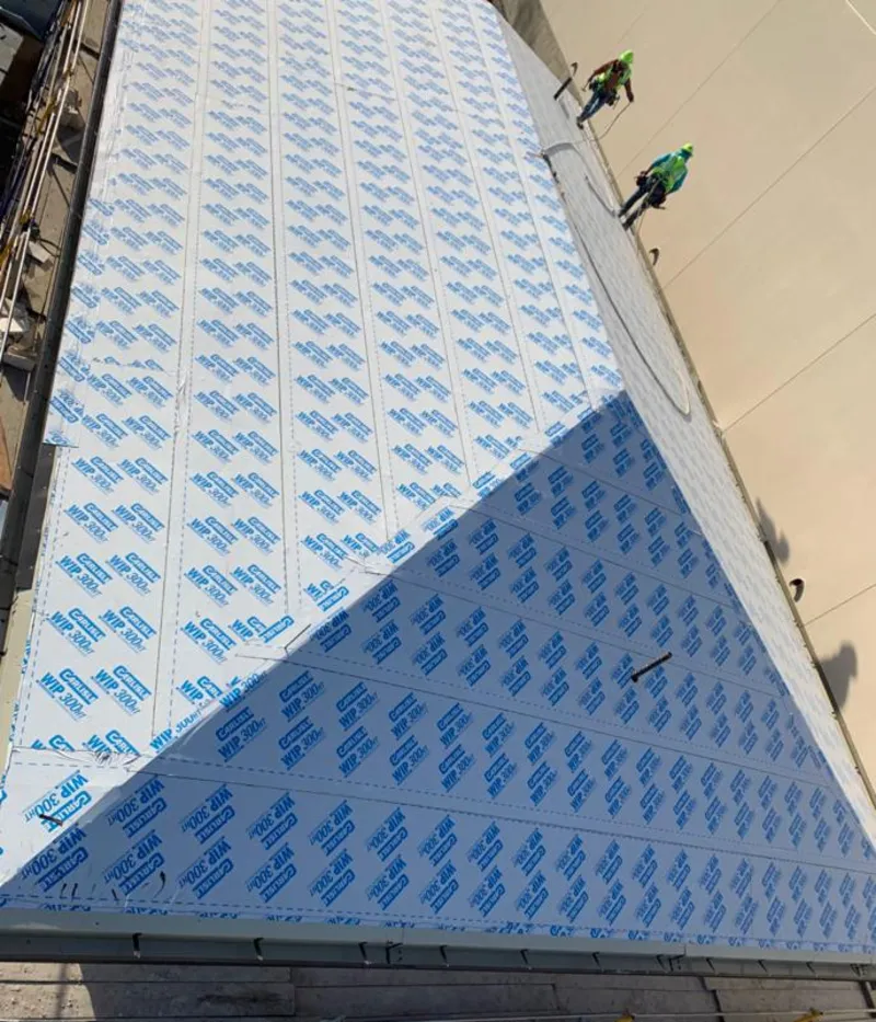 Professional roofers installing underlayment on a metal roof in Barton